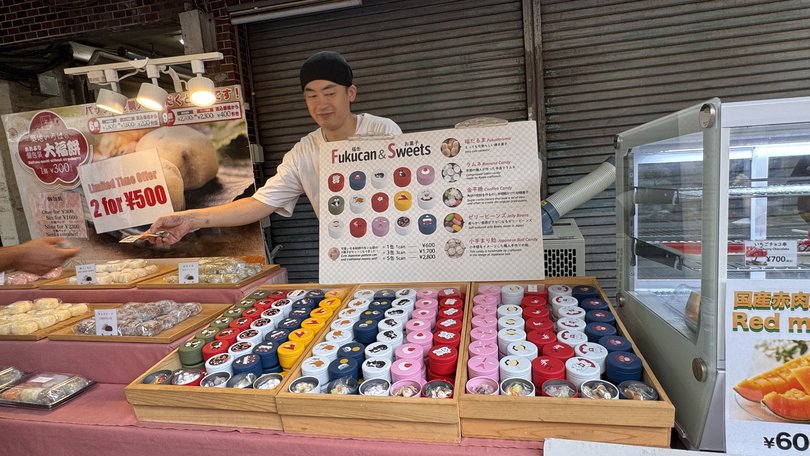 A cheerful and helpful snack and candy vendor at Tsukiji Outer Market.