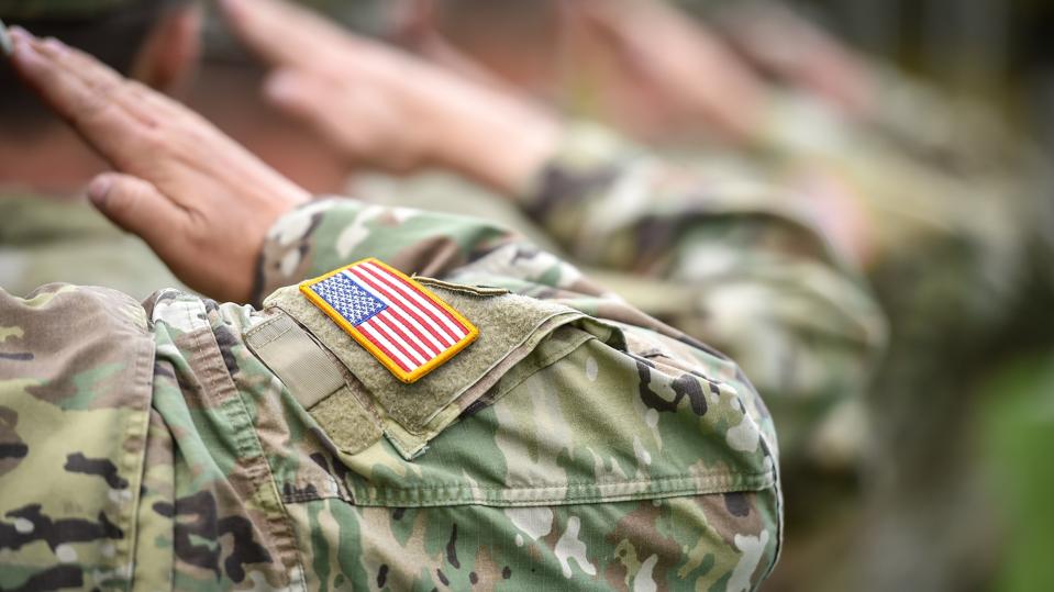 Detail shot with american flag on soldier uniform, giving the honor salute during military ceremony
