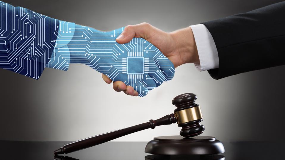 Artificial intelligence hand shaking a human hand over a Judge's gavel. 