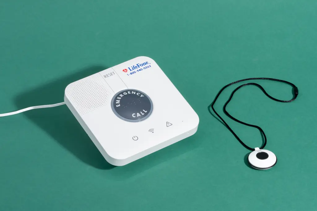 The base and wearable button of the LifeFone At-Home Cellular, our top pick for the best traditional home-based medical alert system.