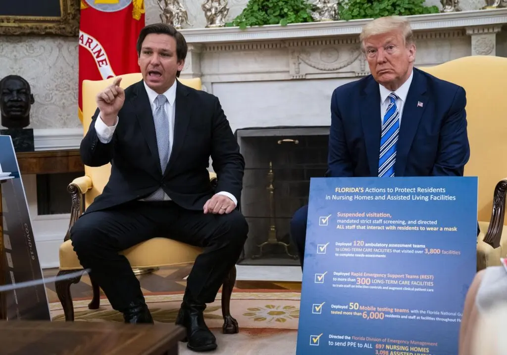 Florida Gov. Ron DeSantis (L) speaks while meeting with U.S. President Donald Trump in the Oval Office of the White House on April 28