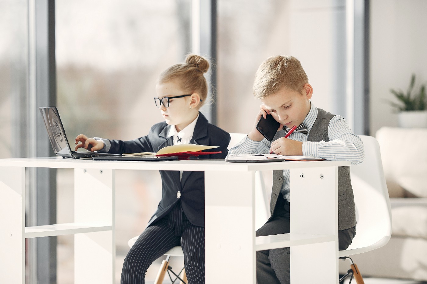 kids dressed like business people and working at a desk on computer and phone