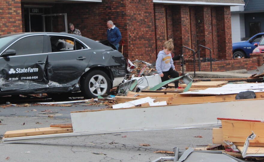 A child walks through damage from the 2021 Kentucky tornado