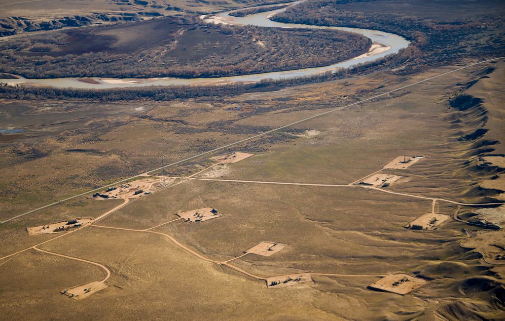 (Trent Nelson  |  The Salt Lake Tribune) An oil and gas field near the Ouray National Wildlife Refuge, pictured on Nov. 17, 2021. After a steady decline in production, drilling activity in the Uinta Basin is expect to rebound with rising energy prices. A new study by the University of Utah has found that 6 to 8% of the basin’s gas production escapes into the atmosphere. This photograph was taken on a flight provided by LightHawk.