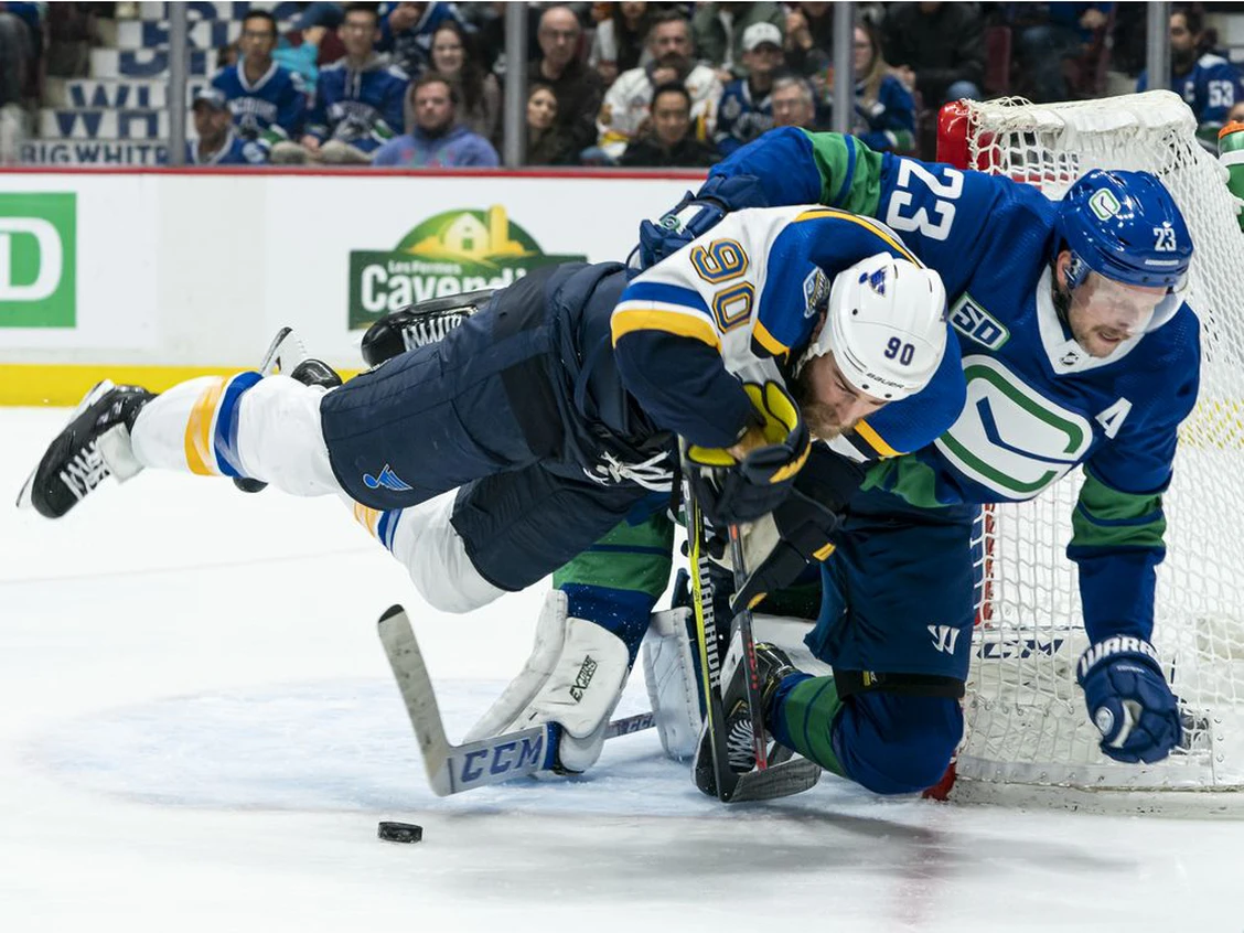 Alex Edler hauls down Ryan O'Reilly of the St. Louis Blues at Rogers Arena on November 5, 2019 in Vancouver, Canada. Photo by Rich Lam /Getty Images