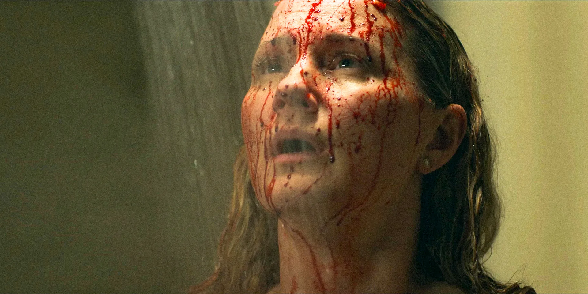 Maryanne (Jennifer Nettles) shocked, with her face splattered in blood, standing under the shower in The Bondsman Season 1