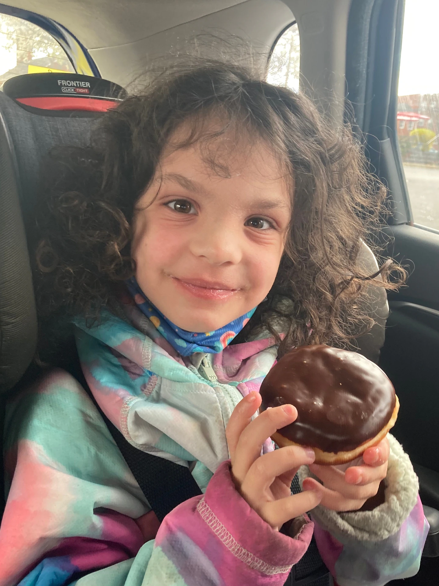 Six-year-old Frankie Macken holds a donut in a car.