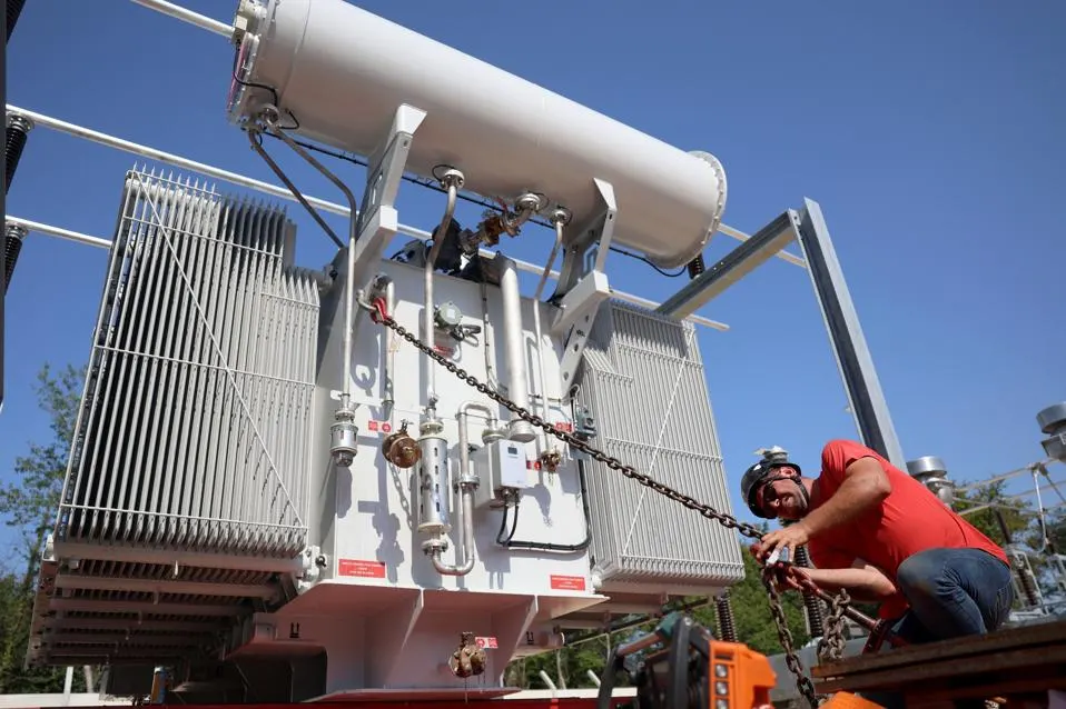 FRANCE: An Enedis employee works on the installation of a new electrical transformer in Pompignac, south-western France, on July 1, 2025 amid a heatwave. Weighing 58 tonnes, the role of this new transformer is to lower the voltage from 63,000 to 20,000 volts, so that electricity can be fed back into the network that supplies power to the surrounding towns