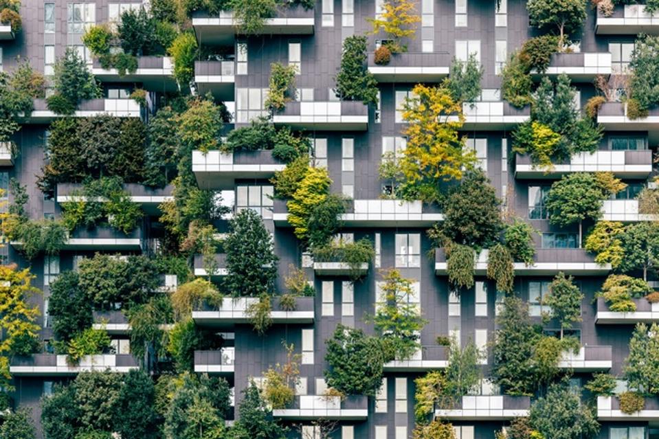 Green plants and trees growing on Bosco Verticale residential apartment building balconies, Milan, Italy