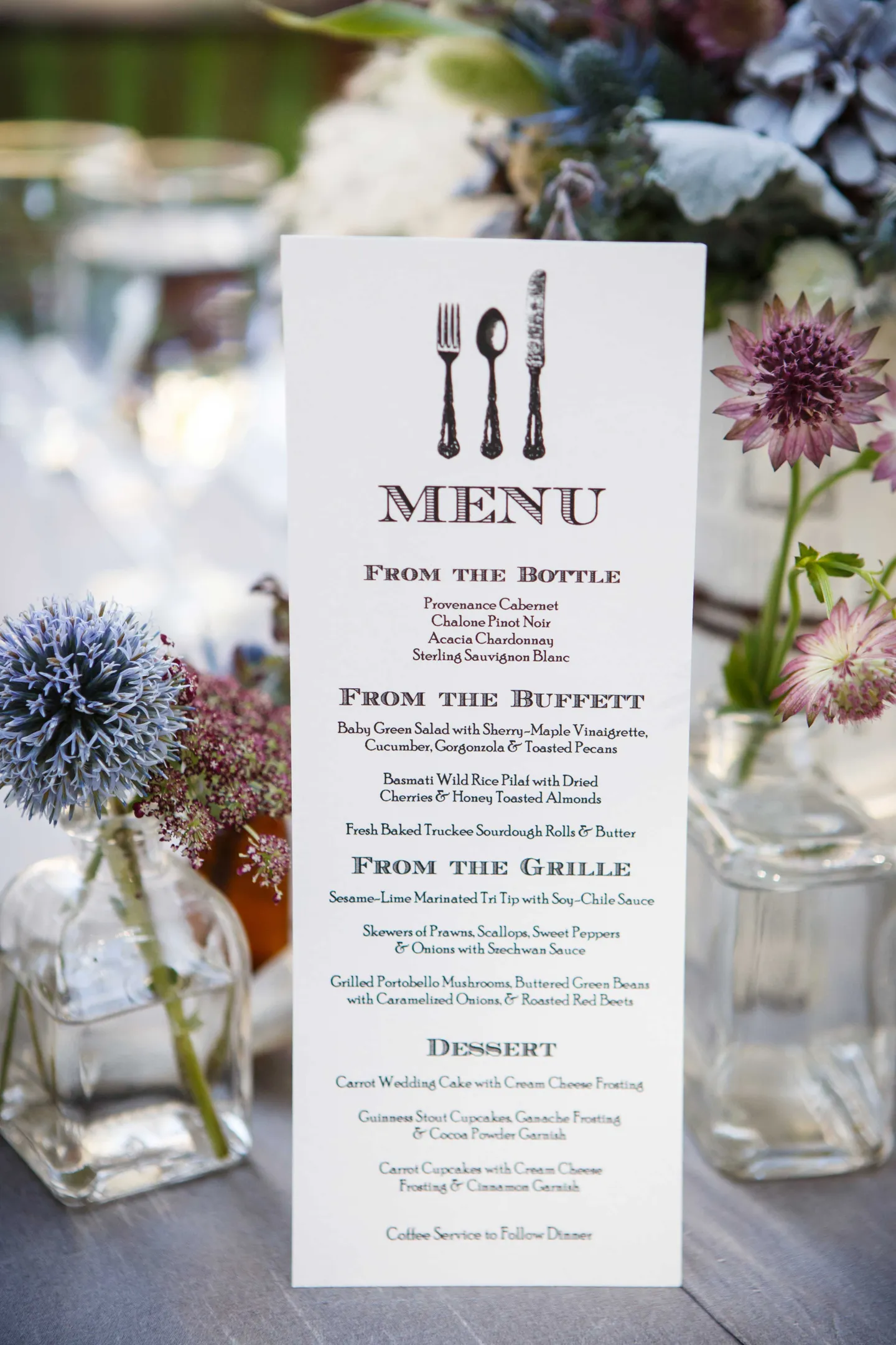 rustic-menu-with-fork-knife-spoon-on-outdoor-reception-table-with-wildflowers-in-small-vessels