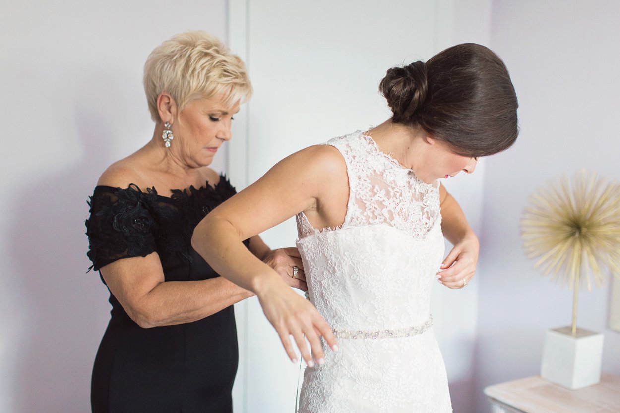 bride-in-monique-lhuillier-sleeveless-mermaid-wedding-dress-mother-of-the-bride-in-black-helping