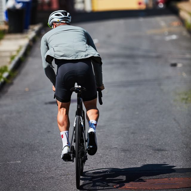 a person riding a bicycle uphill with strong muscles