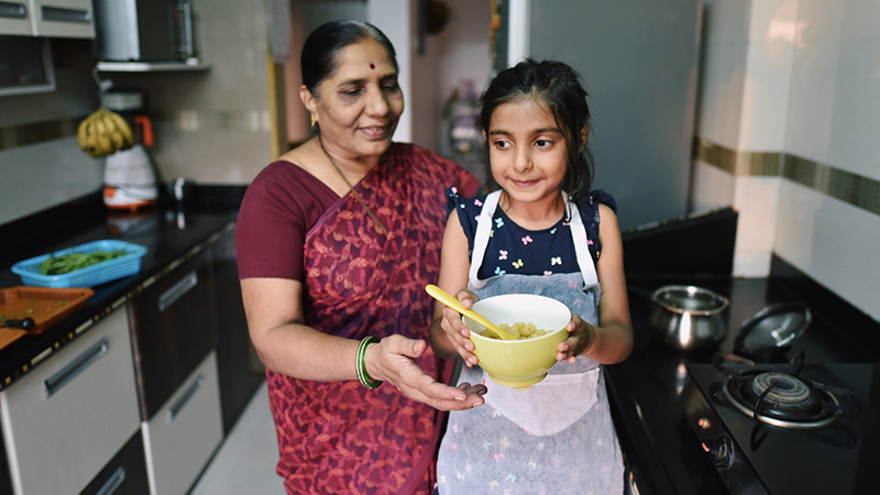 Grandmother and granddaughter preparing meal in the kitchen
