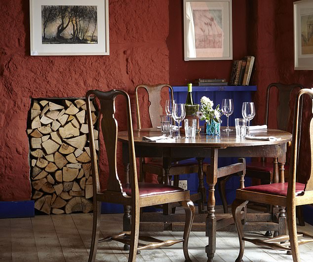 Vibrant: Pictured is The Gurnard’s Head's art-filled dining room, which has views of the garden and moors