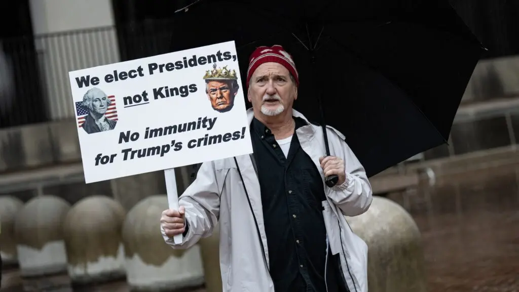 A man protests before former U.S. President Donald Trump's motorcade departs the E. Barrett Prettyman U.S. Courthouse on January 9, 2024 in Washington, DC.