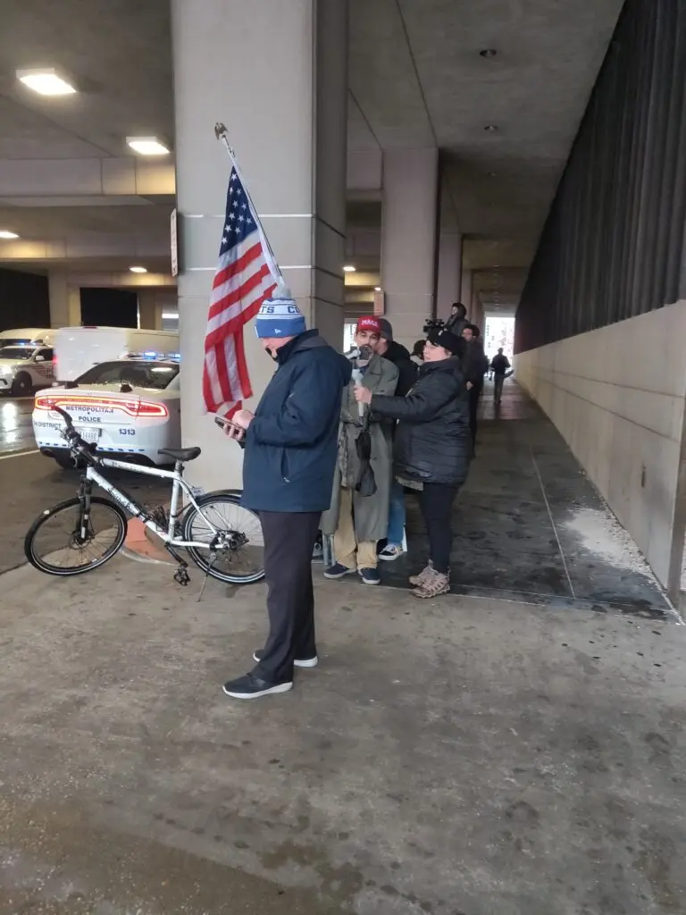 A pair of Trump supporters try to shelter from the rain while waiting outside the D.C. courthouse during the former president's latest appeals hearing. 