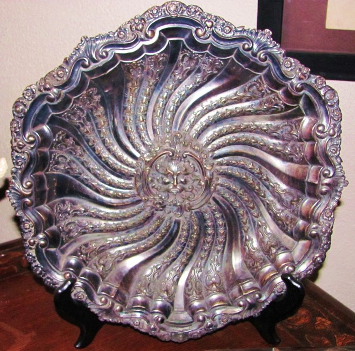 This 19th-century Rococo Revival/Baroque/Gothic German silver repousse tray features scrolls, flowers and swirls surrounding a central medieval Green Man. Measuring 14 ½ inches in diameter, this item is currently for sale on eBay for 1999.00.