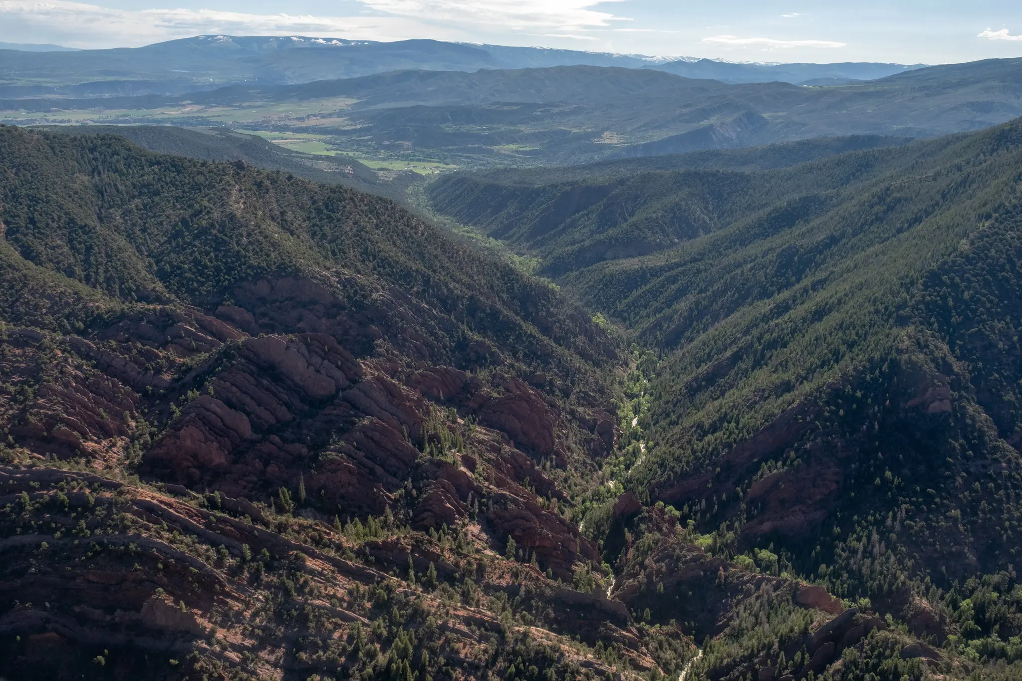 The Thompson Creek running between high, green hills.