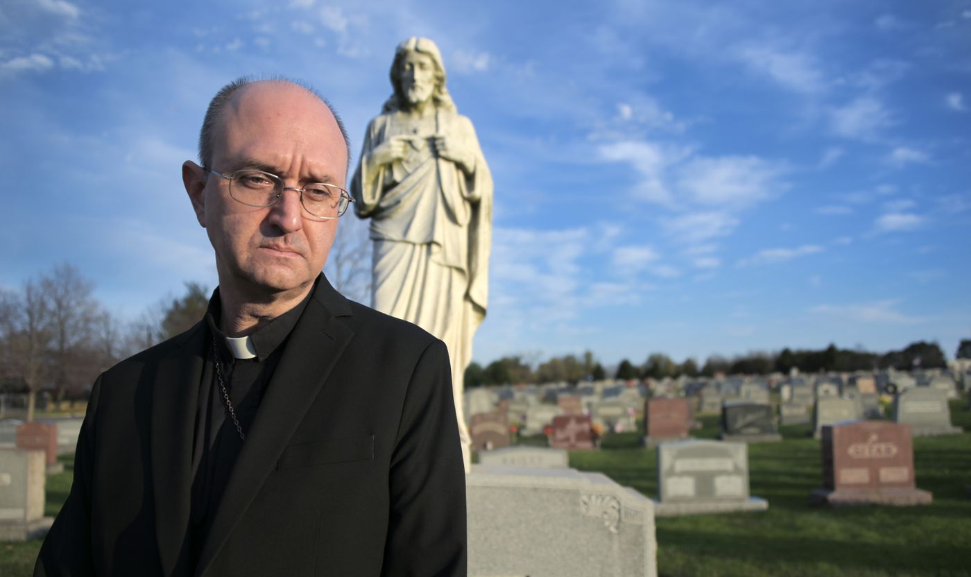 Bruce Lewandowski, auxiliary bishop of the Archdiocese of Baltimore and pastor of Sacred Heart of Jesus Church, stands in the church cemetery. The church has lost 36 parishioners to the coronavirus pandemic. (Karl Merton Ferron/Baltimore Sun Staff)